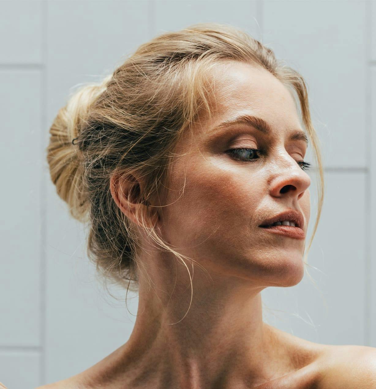 woman with her hair tied up while she looks to the right