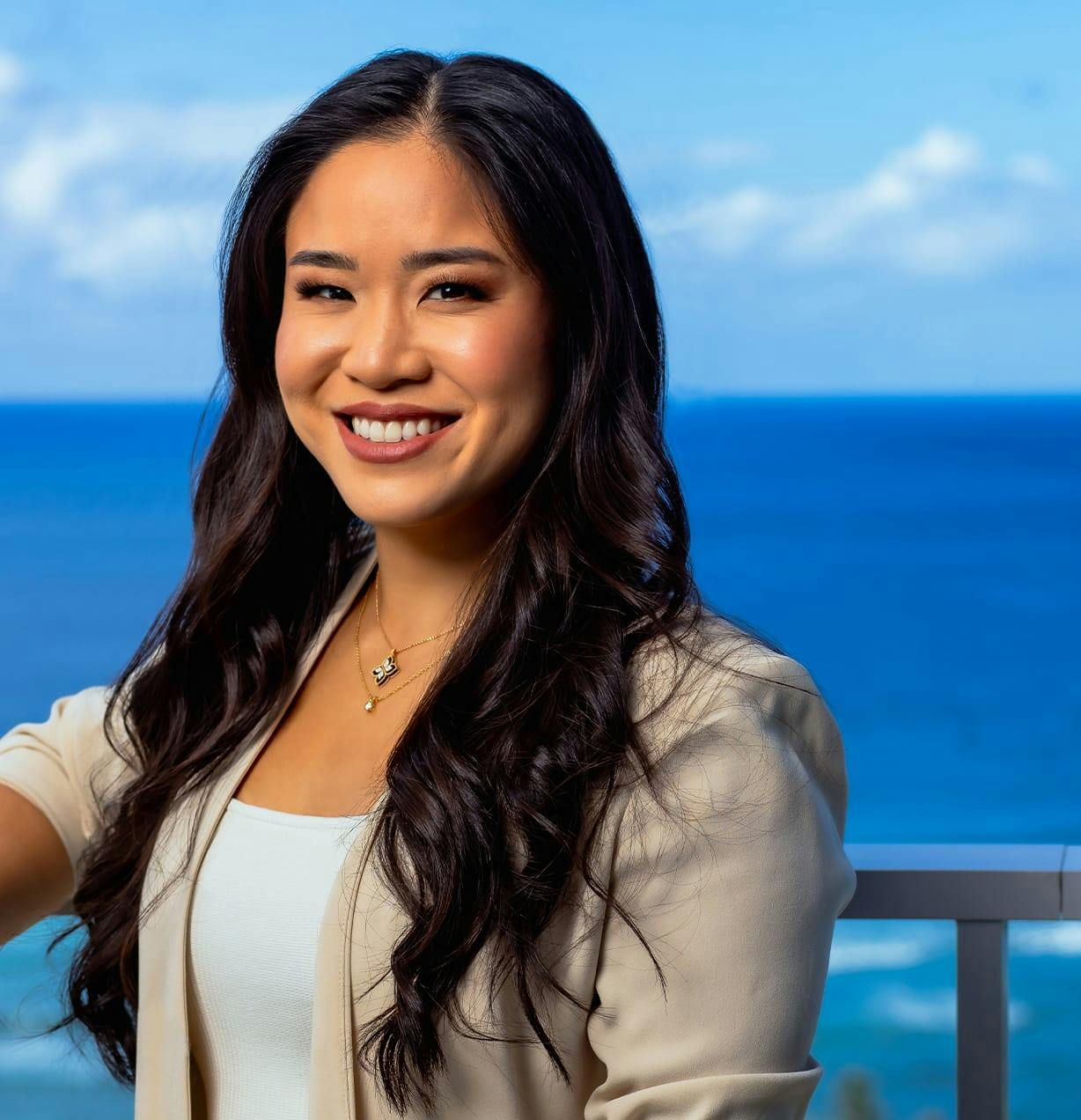 woman smiling with ocean view behind her
