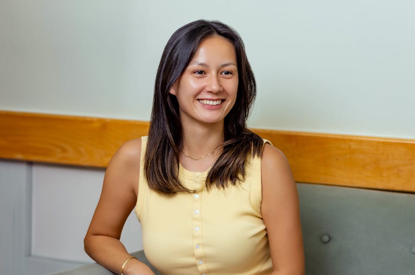 woman in yellow top smiling while sitting on couch
