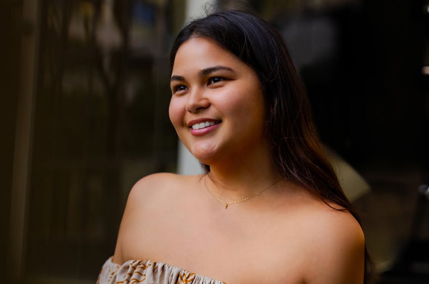 woman smiling with bushes behind her