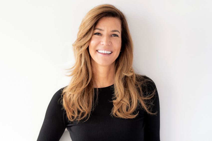 woman pulling back anothers woman's hair while she sits in a chair