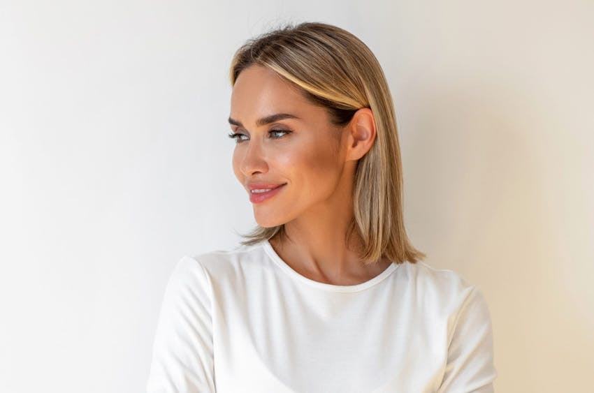 woman moving another's woman's hair out of the way while she is sitting down