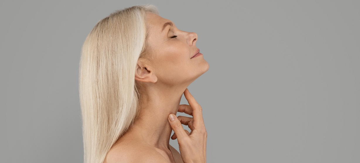 Mature woman touching her neck.
