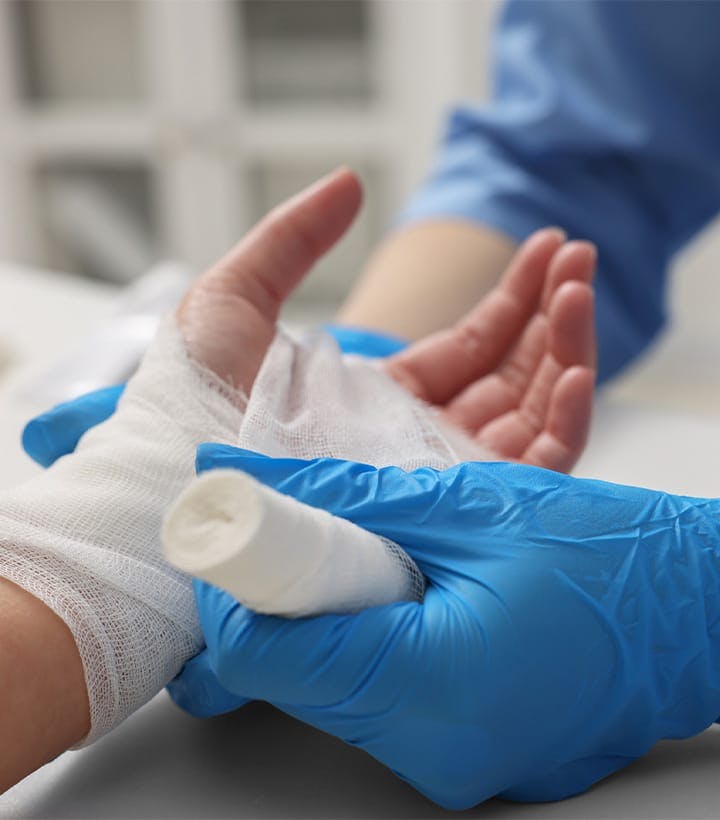 nurse wrapping a person's hand in gauze