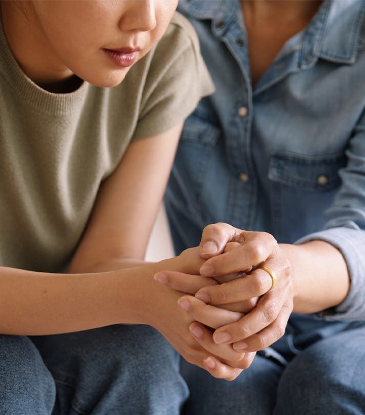 two sad people holding hands