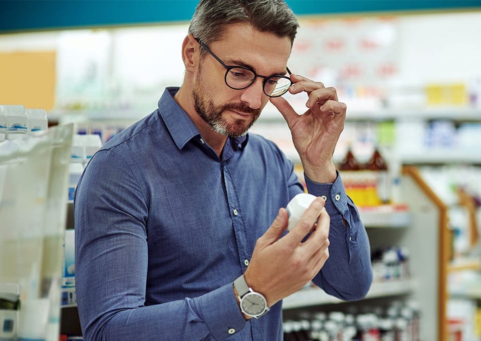 man looking at a bottle of pills