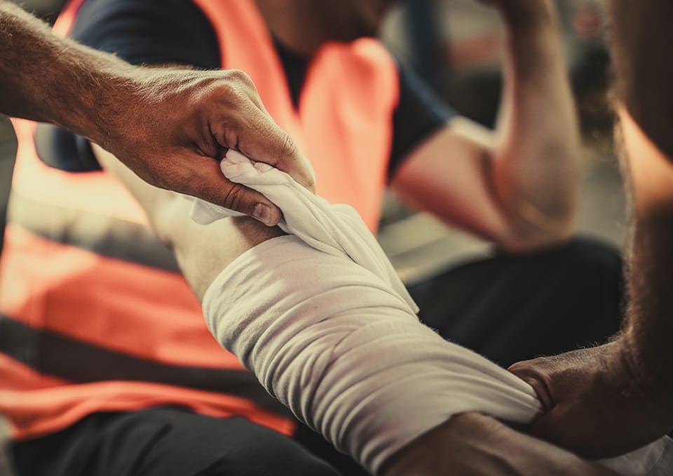person getting their arm wrapped in bandages