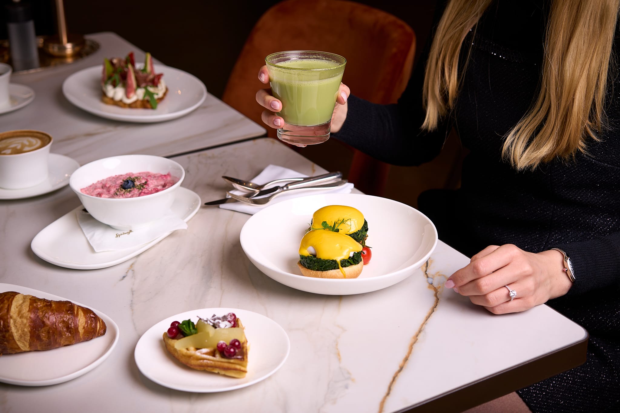 Confiserie Sprüngli Restaurant und Cafe Frühstückstisch mit diversen Speisen wie Bichermüesli, Eggs Benedict, Waffeln, Croissants und Matcha