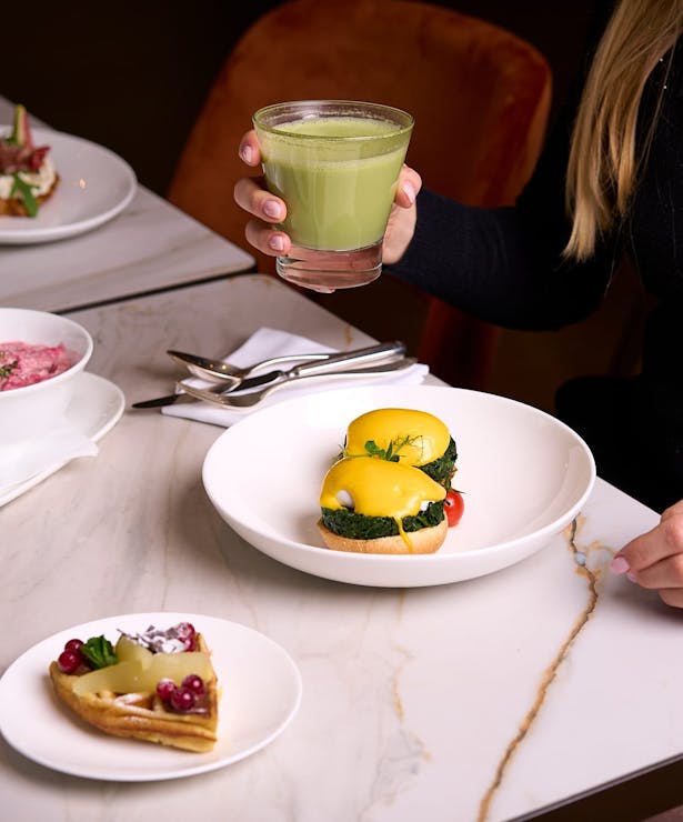 Confiserie Sprüngli Restaurant und Cafe Frühstückstisch mit diversen Speisen wie Bichermüesli, Eggs Benedict, Waffeln, Croissants und Matcha