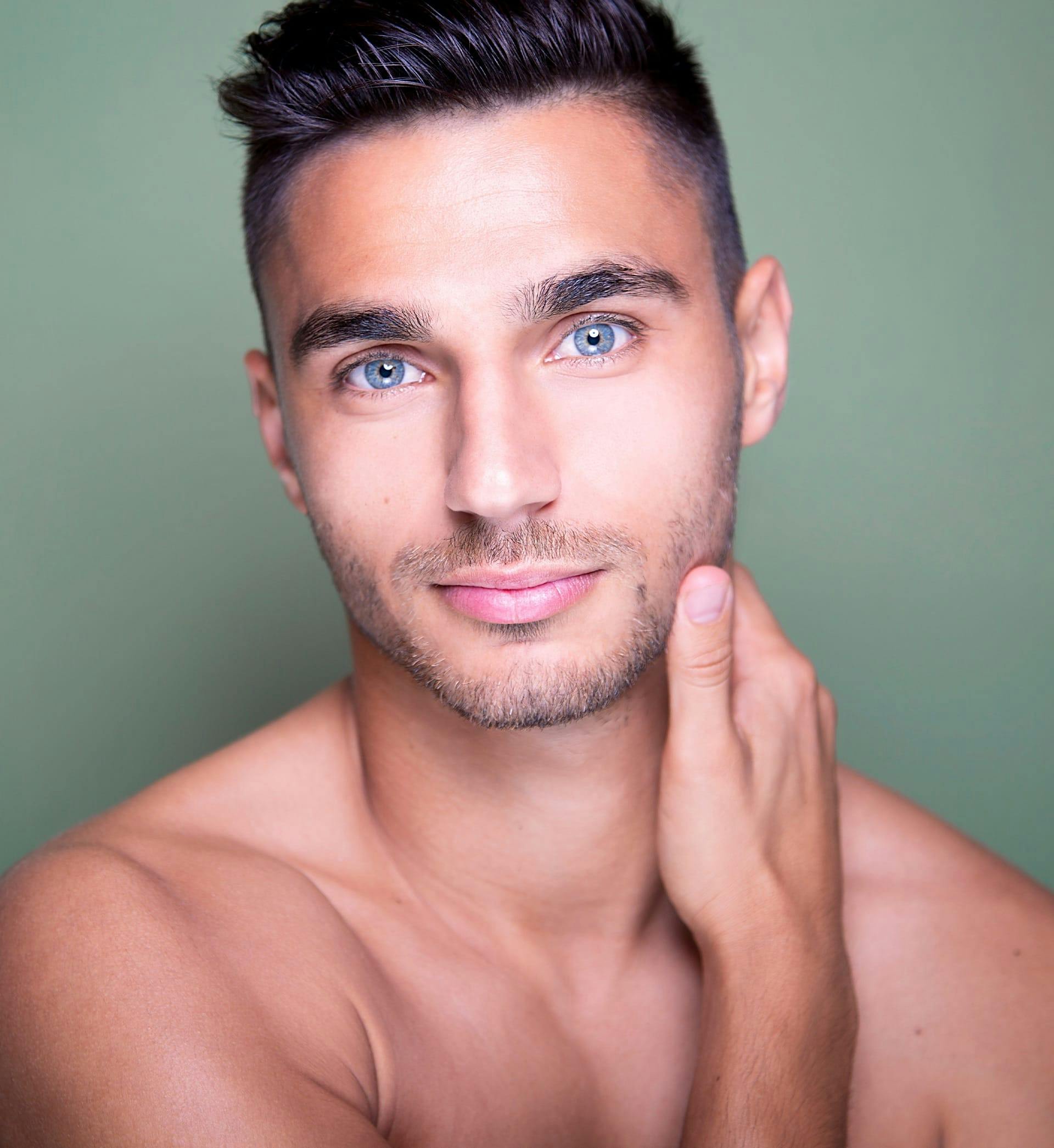 shirtless man touching his neck