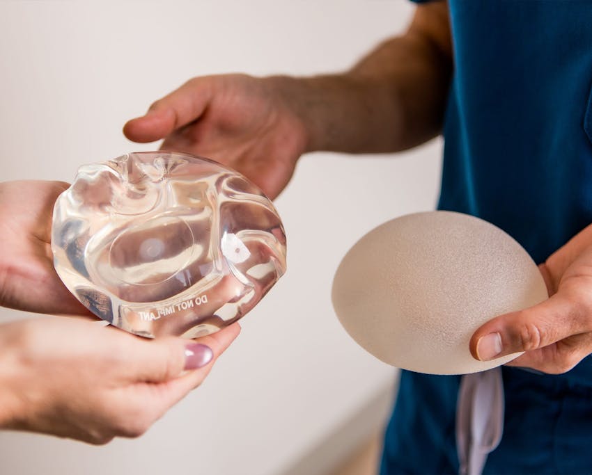 doctor holding breast implants