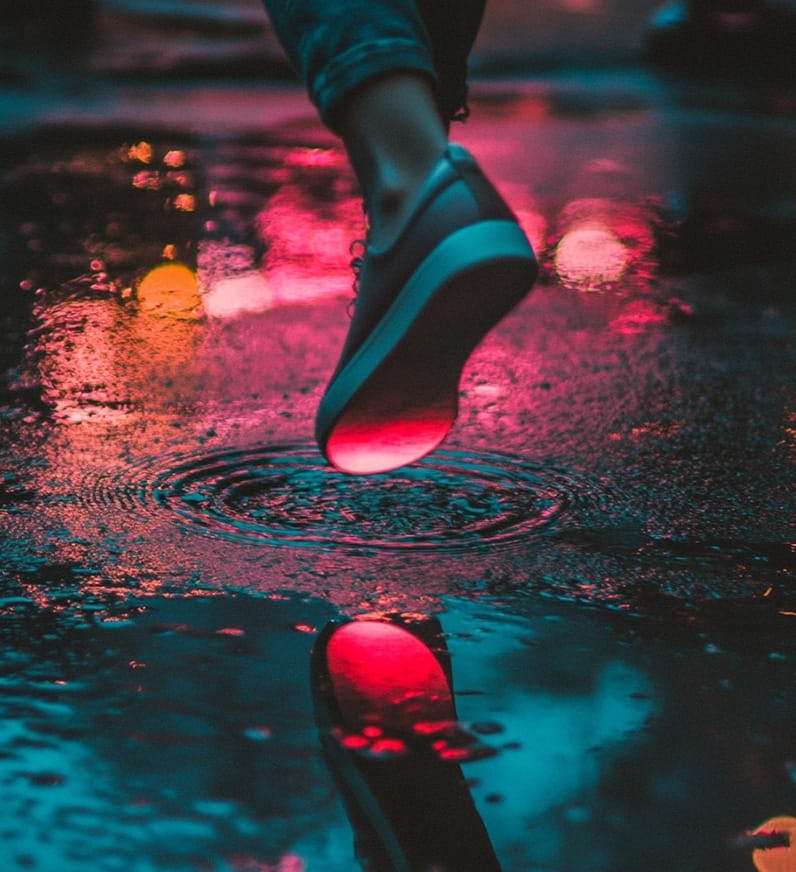 person stepping in puddle in shoe