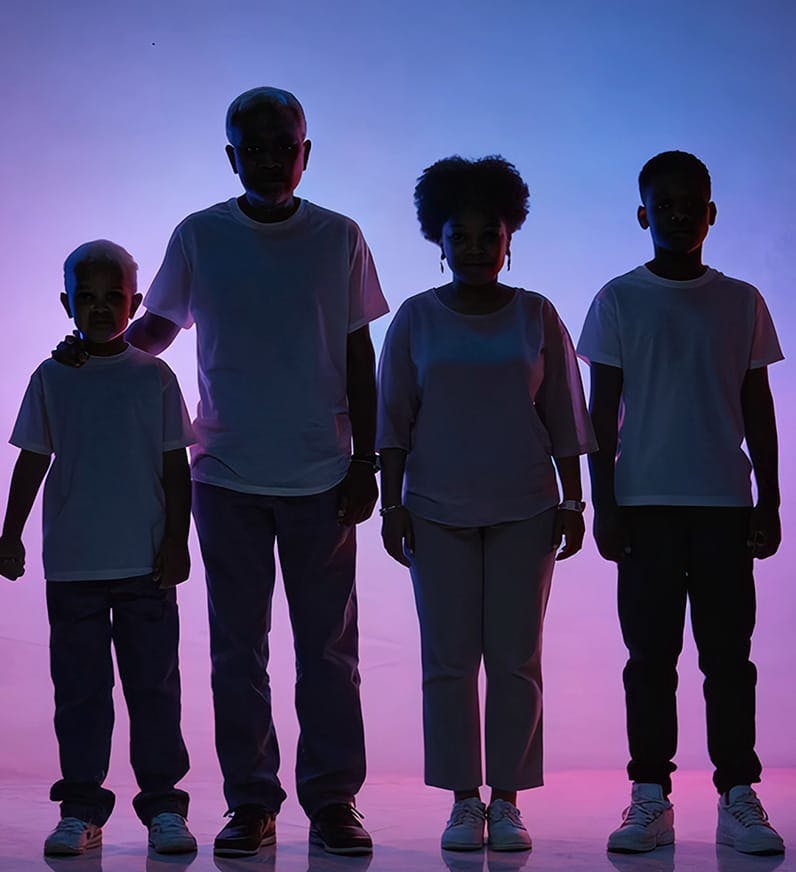 3 males and 1 female standing together with bright background