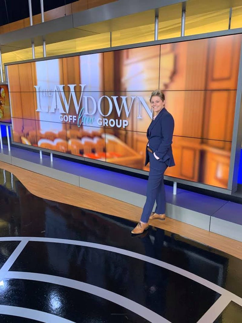 Attorney Goff standing in front of a sign that says The Law Down