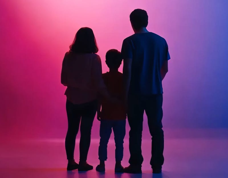 family standing in front of blue and pink background