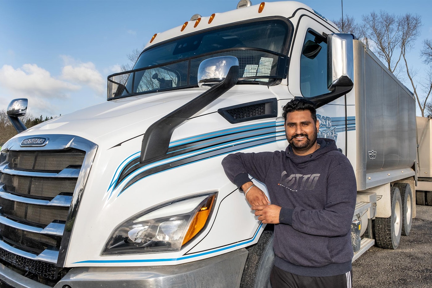 Sam Sandhu next to S&B Haulage's 6x4 Freightliner Cascadia 116 Tipper from Keith Andrews.