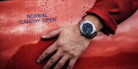 Hand with watch on red background