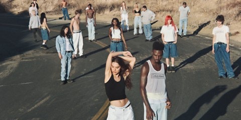 People standing in a road wearing jeans