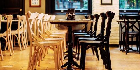 Row of dark and light chairs around a table