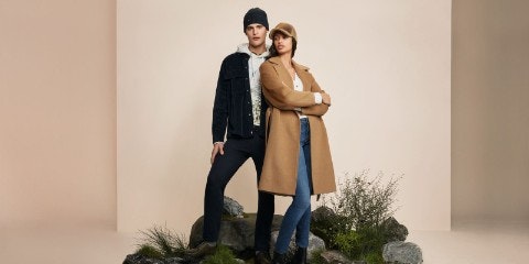 Man and woman standing on rocks posing for camera