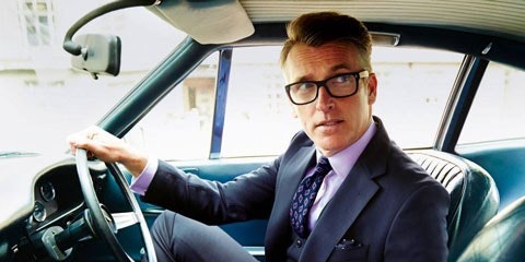 Man in suit sitting in drivers seat of car
