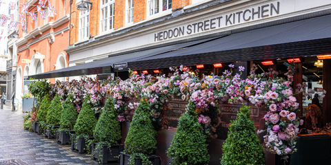 Outside view of a restaurant with green and pink plants