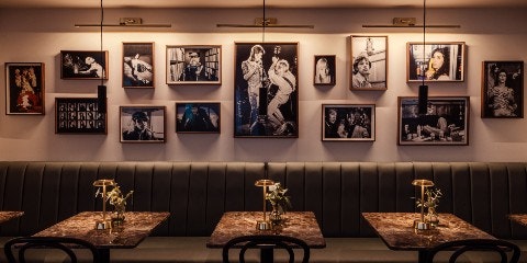 Table and chairs with portraits on the wall