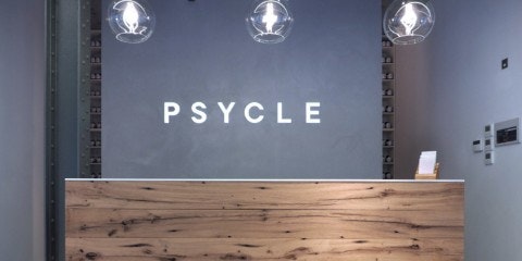 Desk in front of Psycle logo on a wall