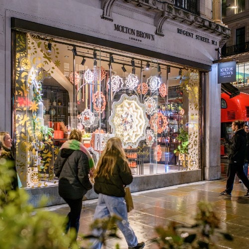 People walking past a shop lite up
