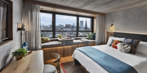 Room with bed and desk, window looking out over London