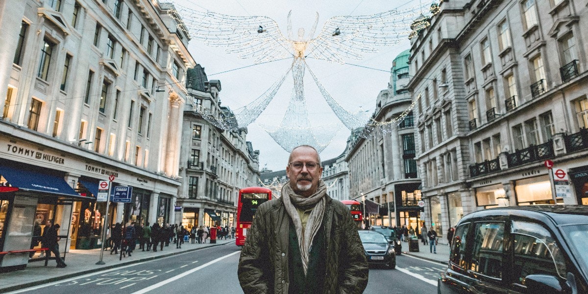 Man standing in front of Christmas lights on street