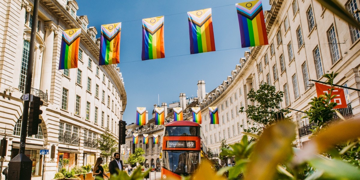 Pride flags above red London bus