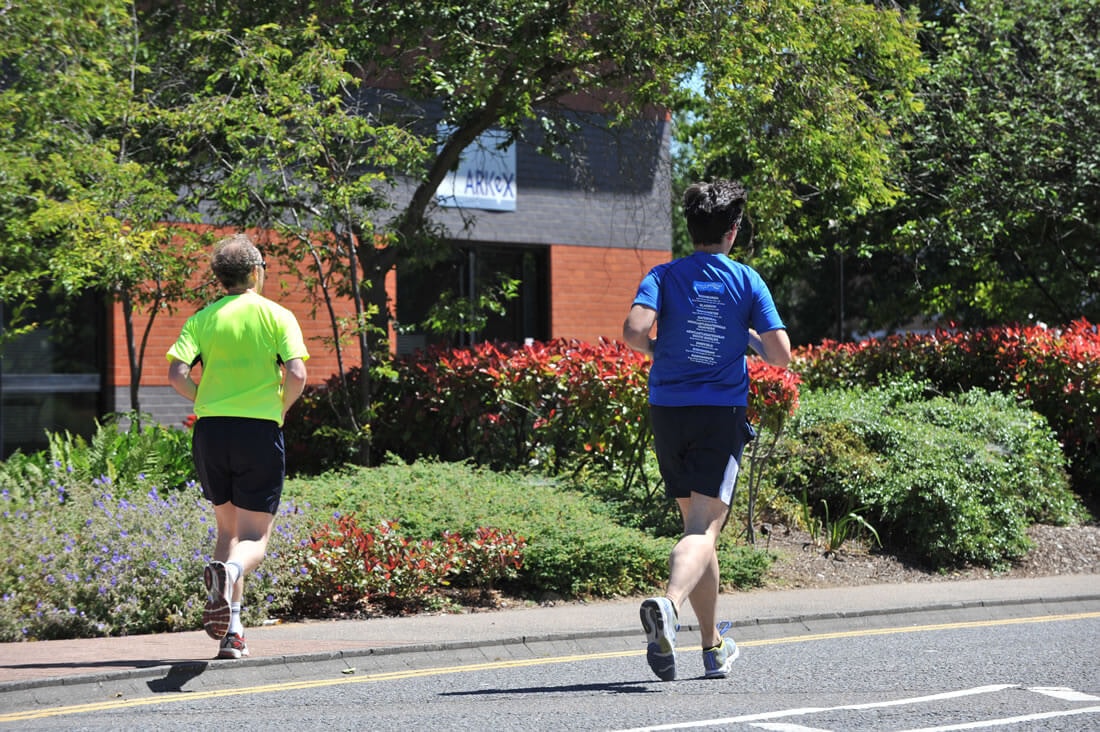 Two people running in front of a building