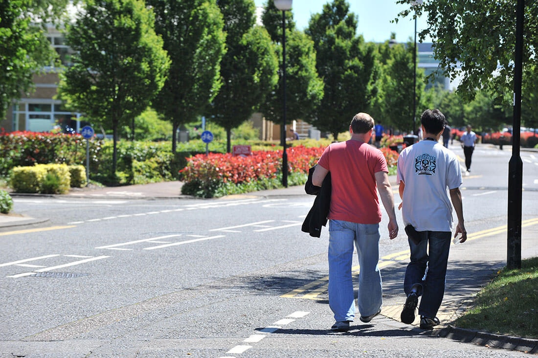 Two people walking along the road