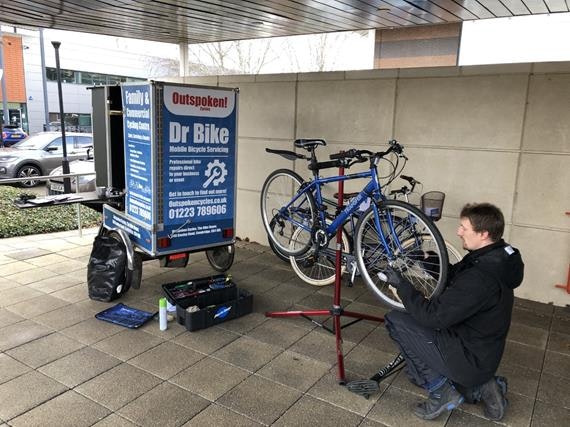 Man with bike being fixed