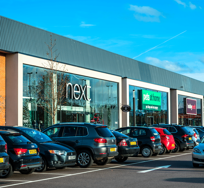 Next logo on building with cars parked