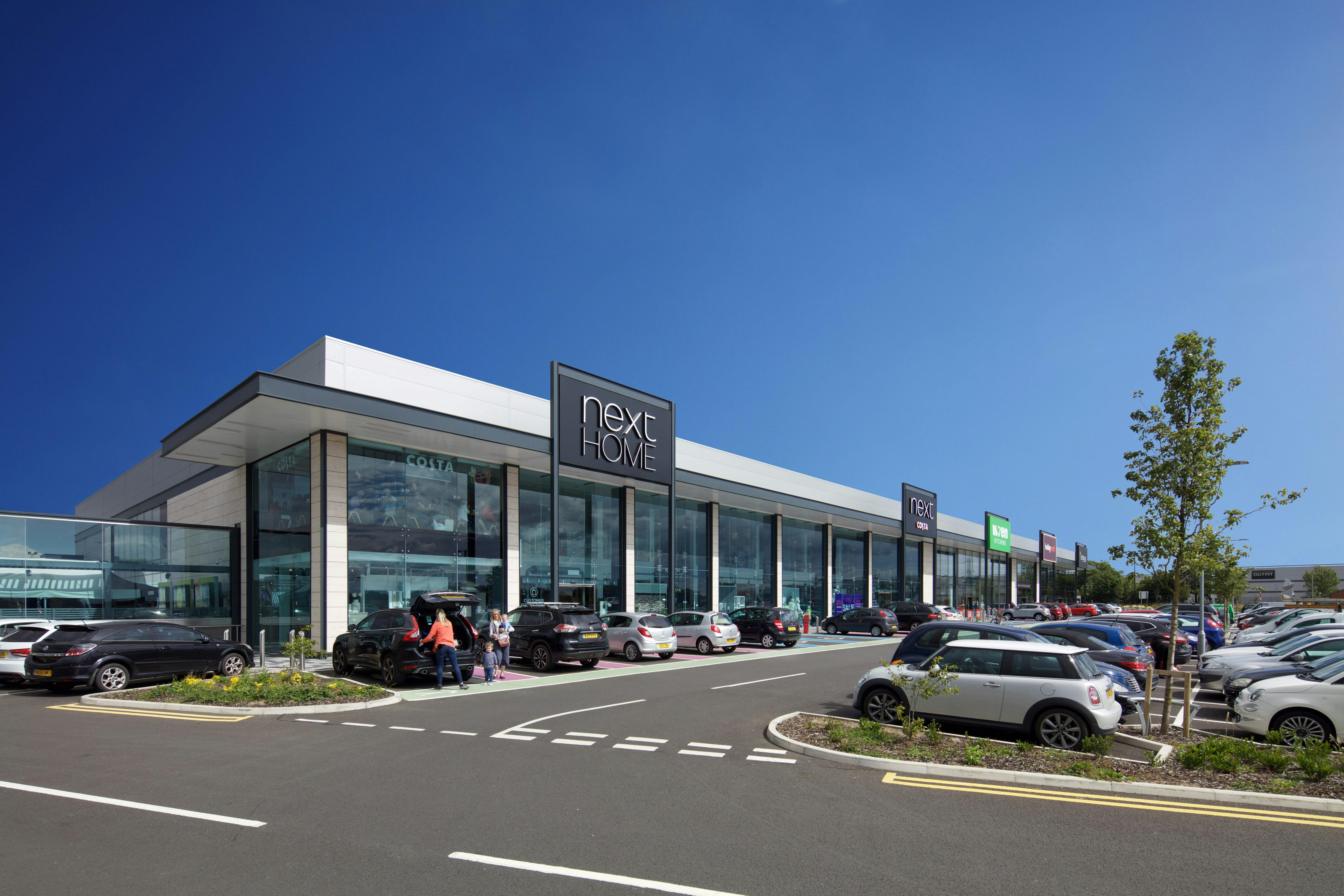 Next Home logo on building with cars parked