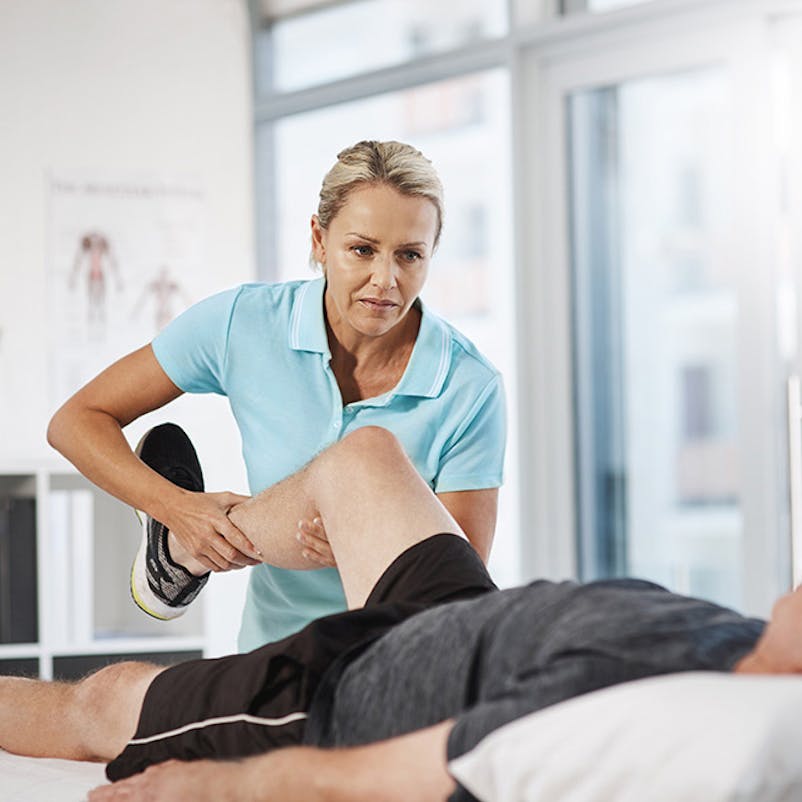 PT stretching patient's leg