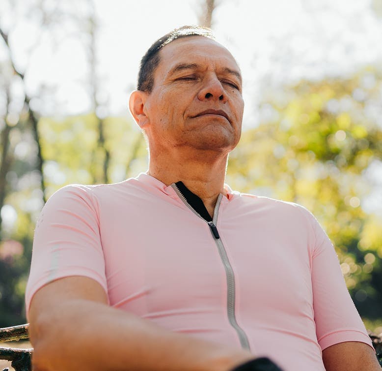 man outside with his eyes closed