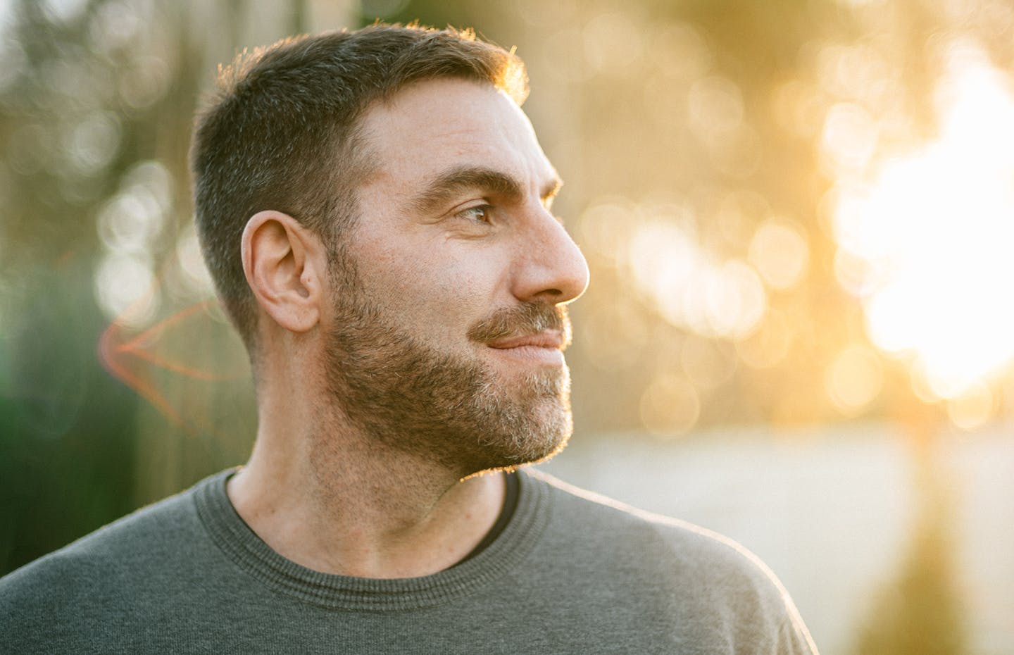 man outside with the sun shining behind him