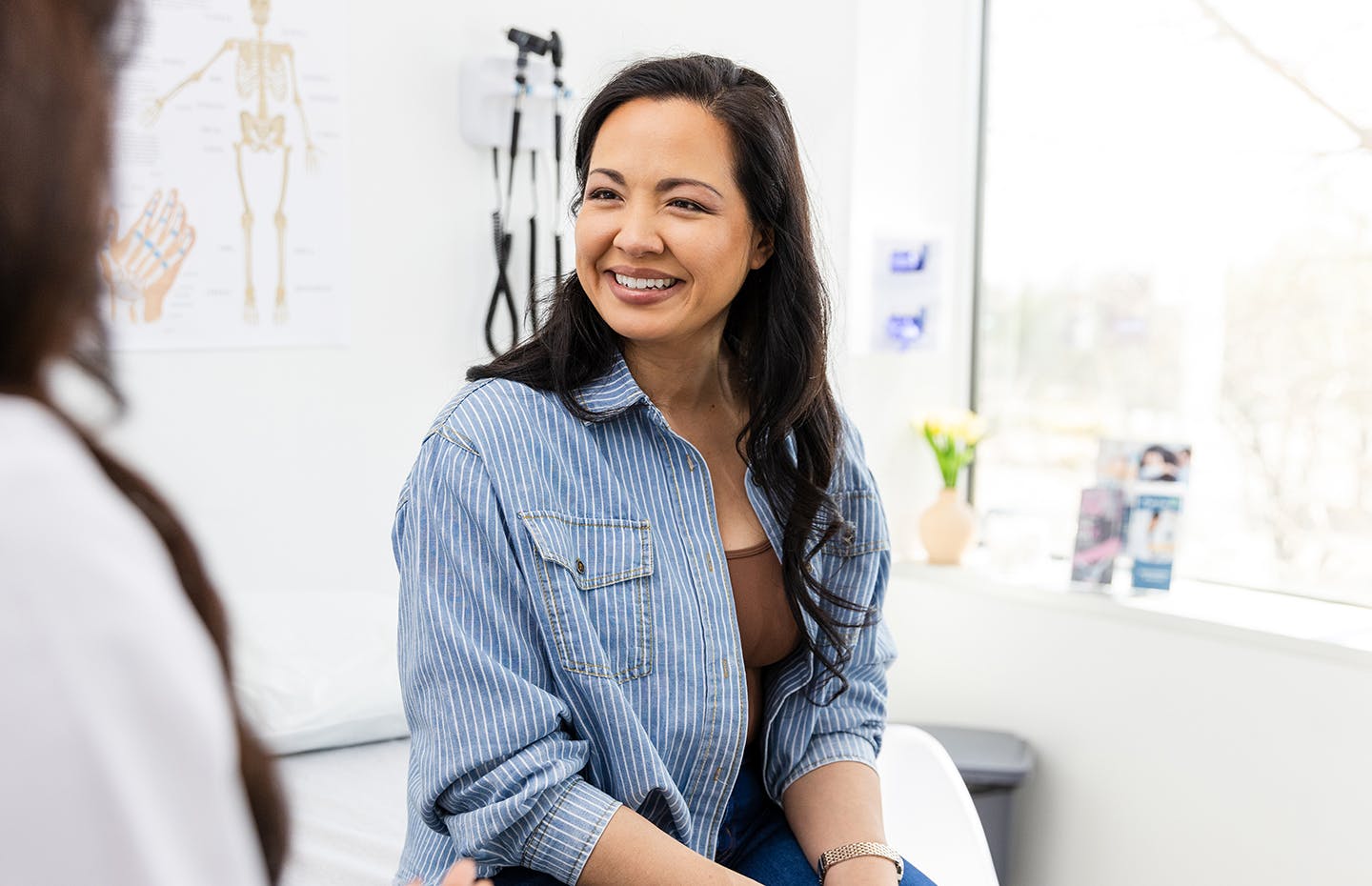 woman in a blue and white striped top at a doctor's appointment