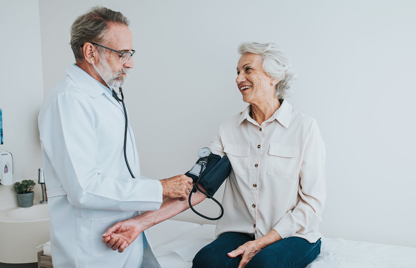 doctor checking an older woman's blood pressure