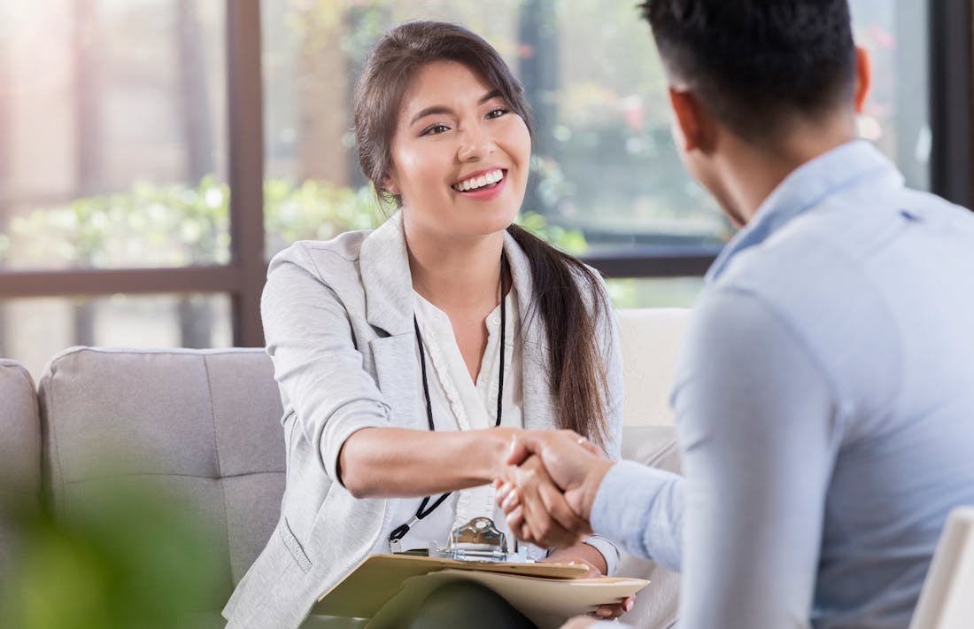 staff shaking patient's hand and smiling