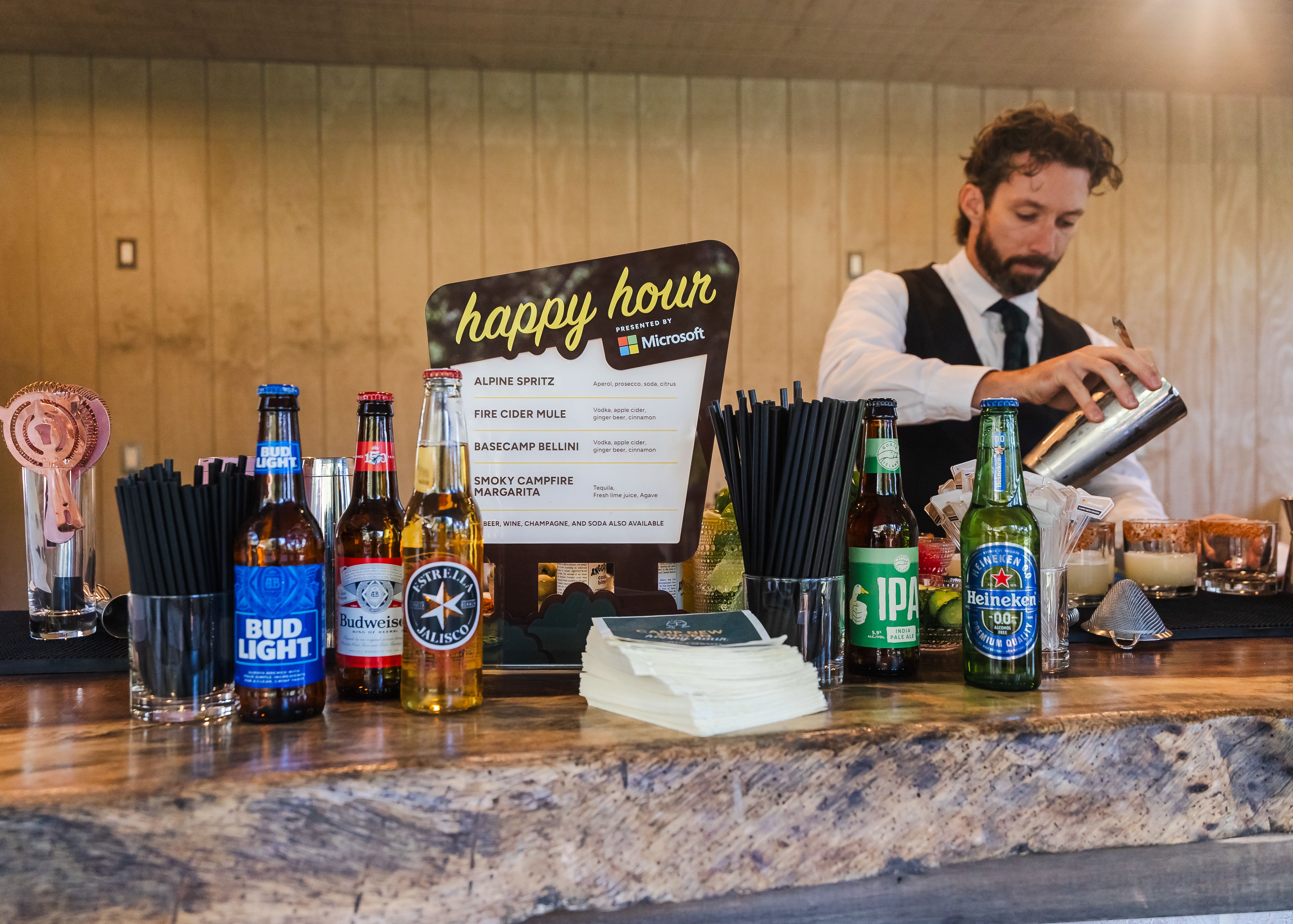 Microsoft-sponsored happy hour setup at Camp New Engen 2026 with a bartender and event menu at the Malibu marketing summit.