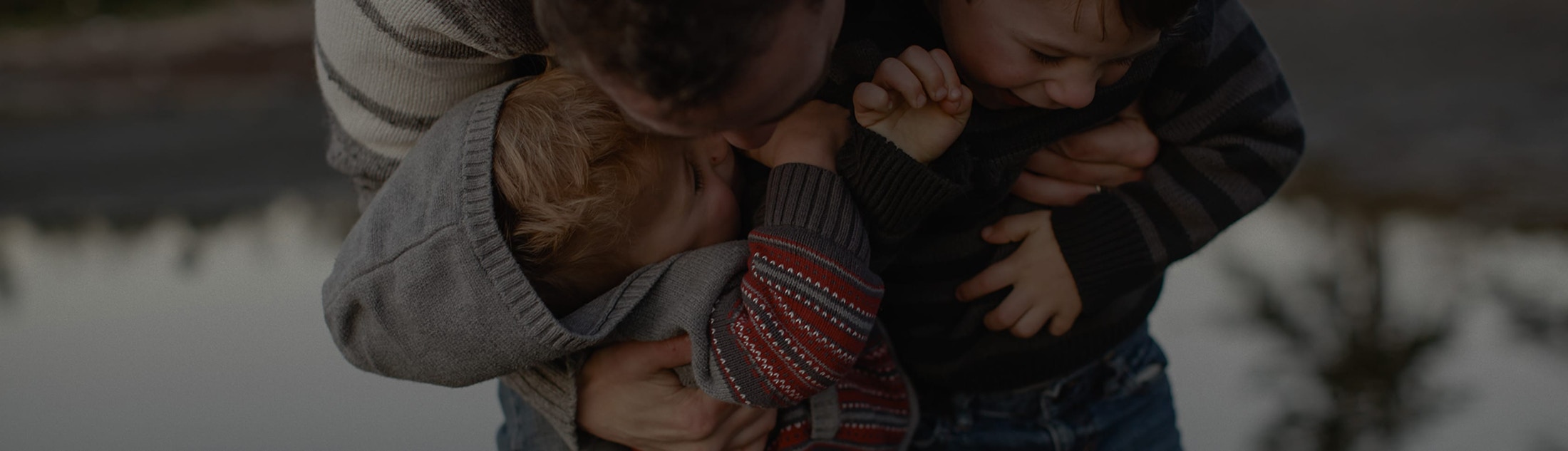 Father holding two happy kids.