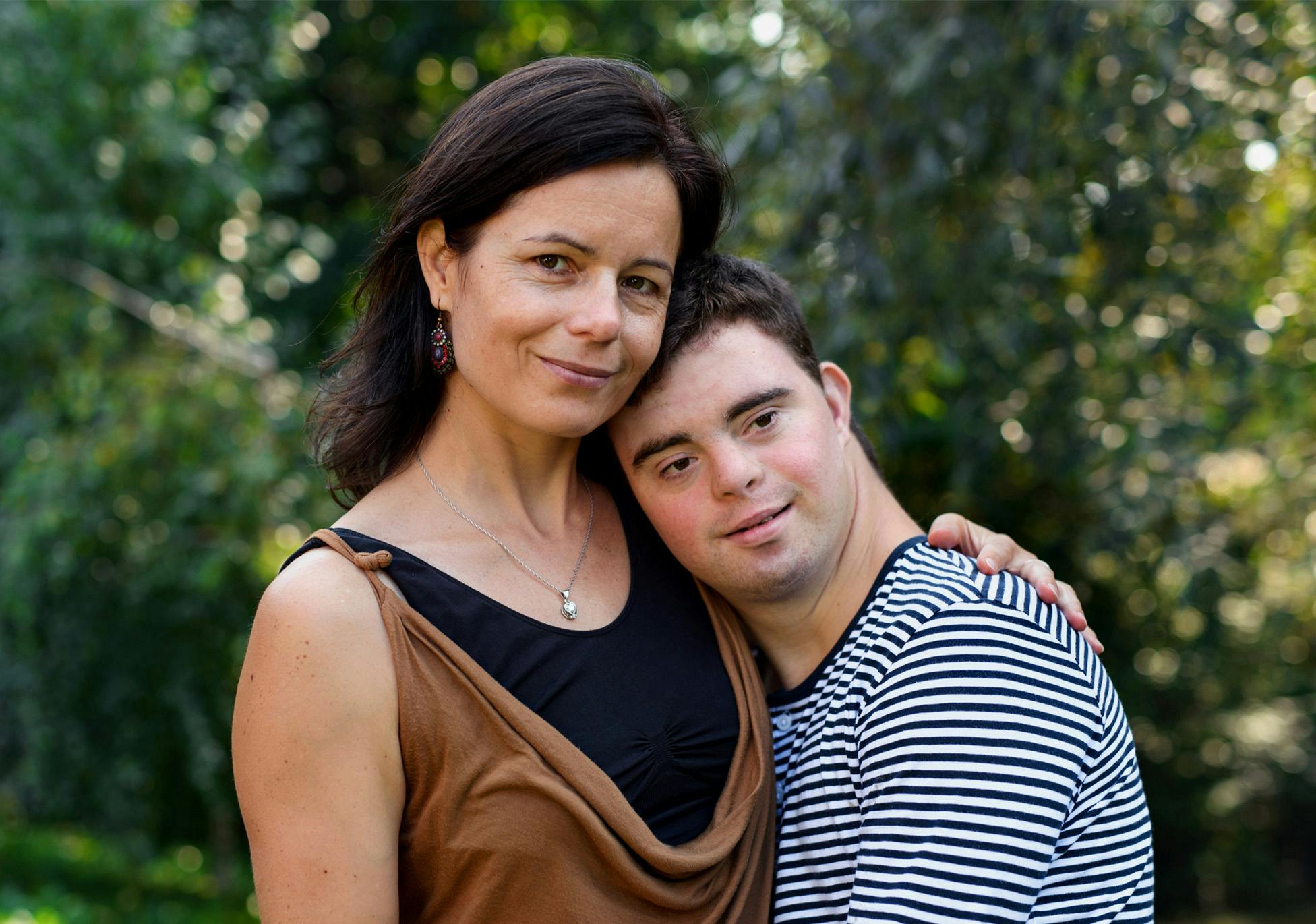 mother and her special needs son hugging eachother outdoors