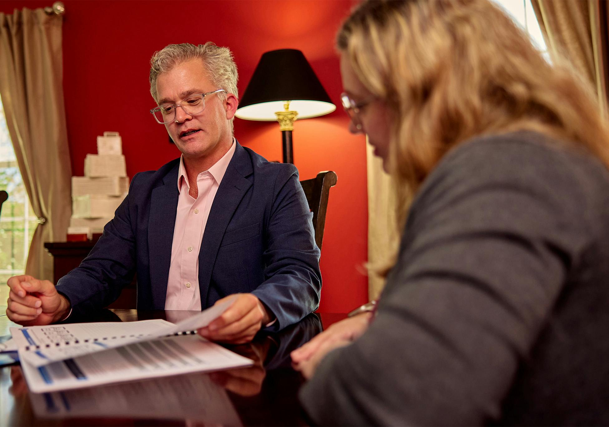 male attorney showing forms to female client at table