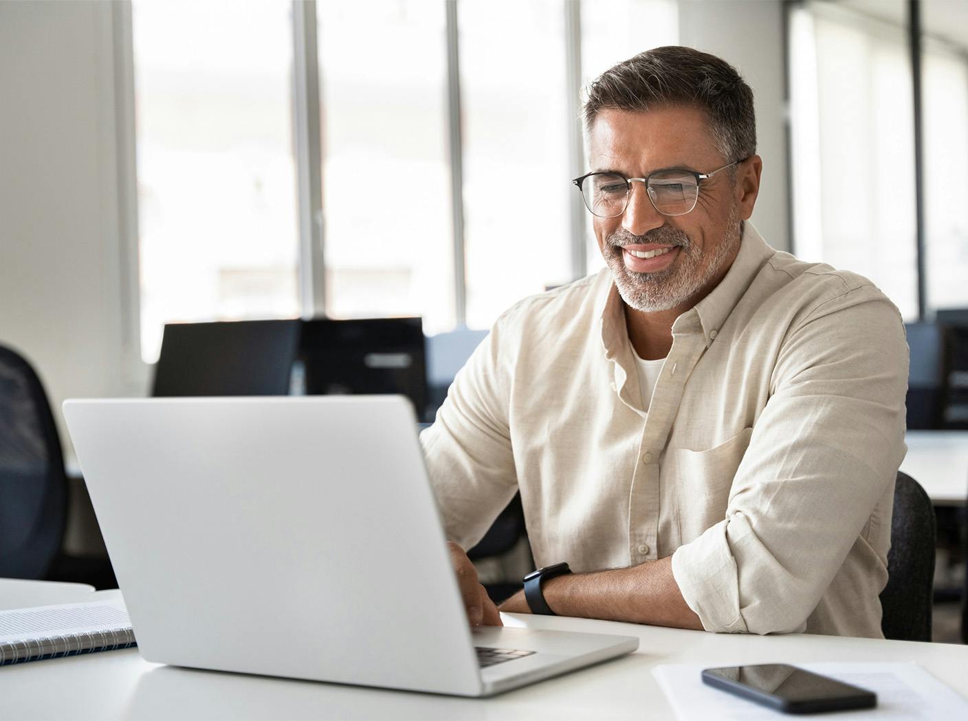 man smiling while working on laptop