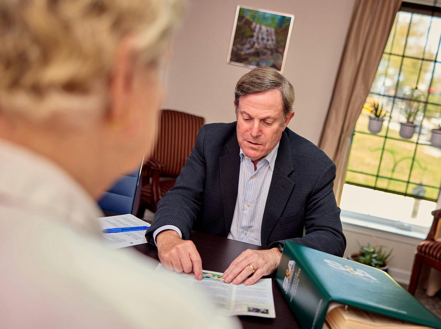 male attorney showing trifold document to client