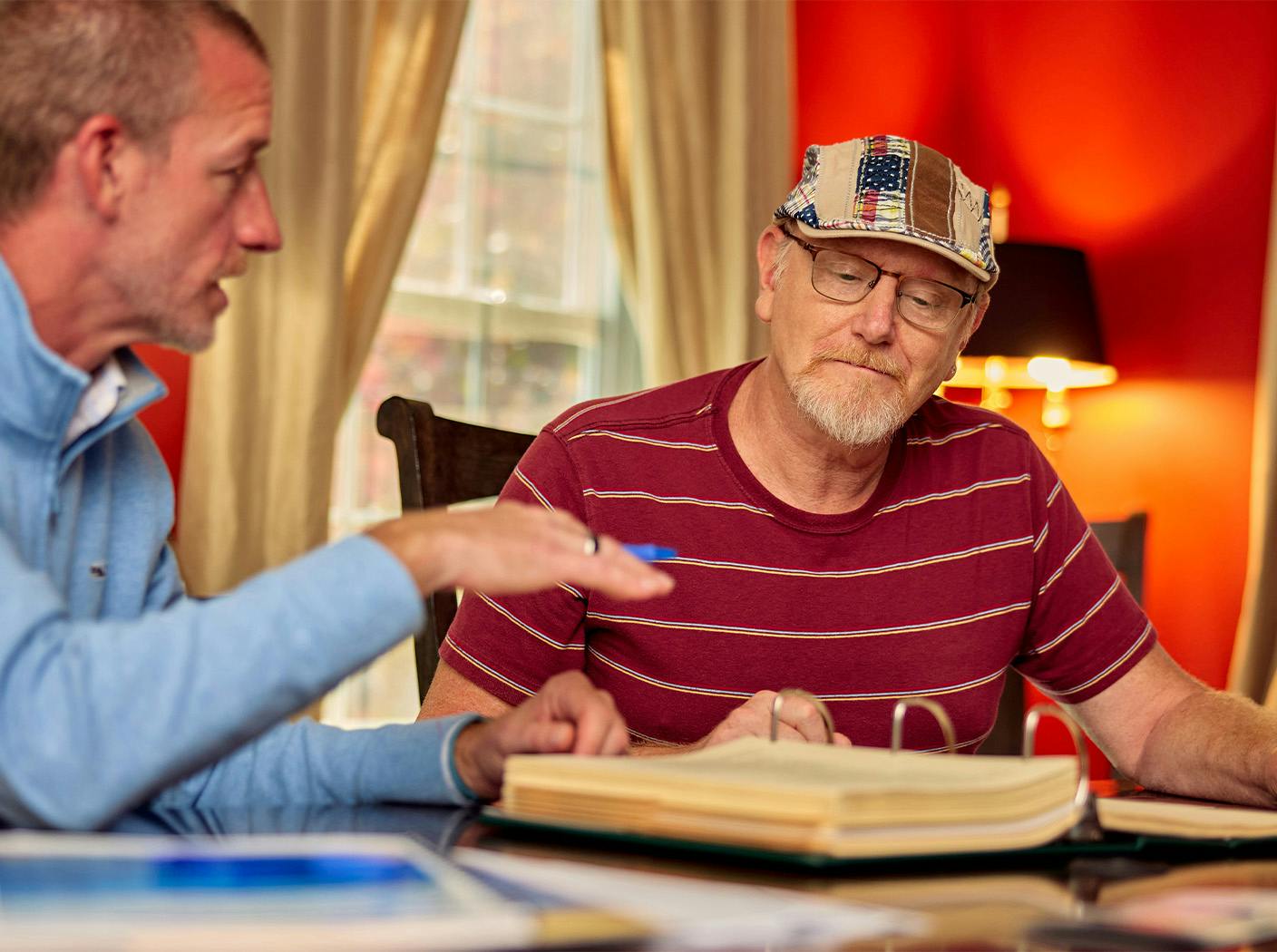 male attorney speaking to male client with documents on the table